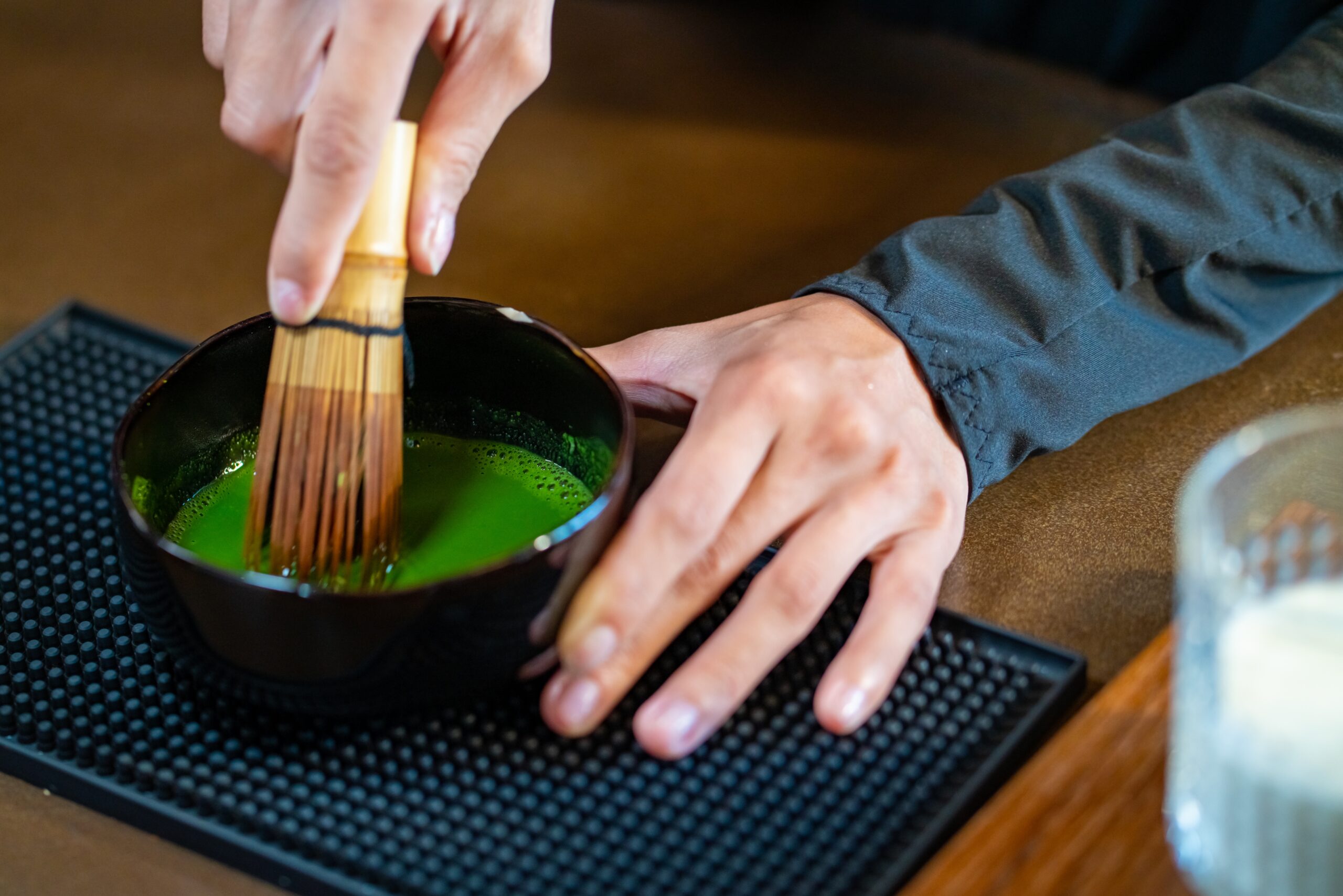 a person making matcha with chasen
